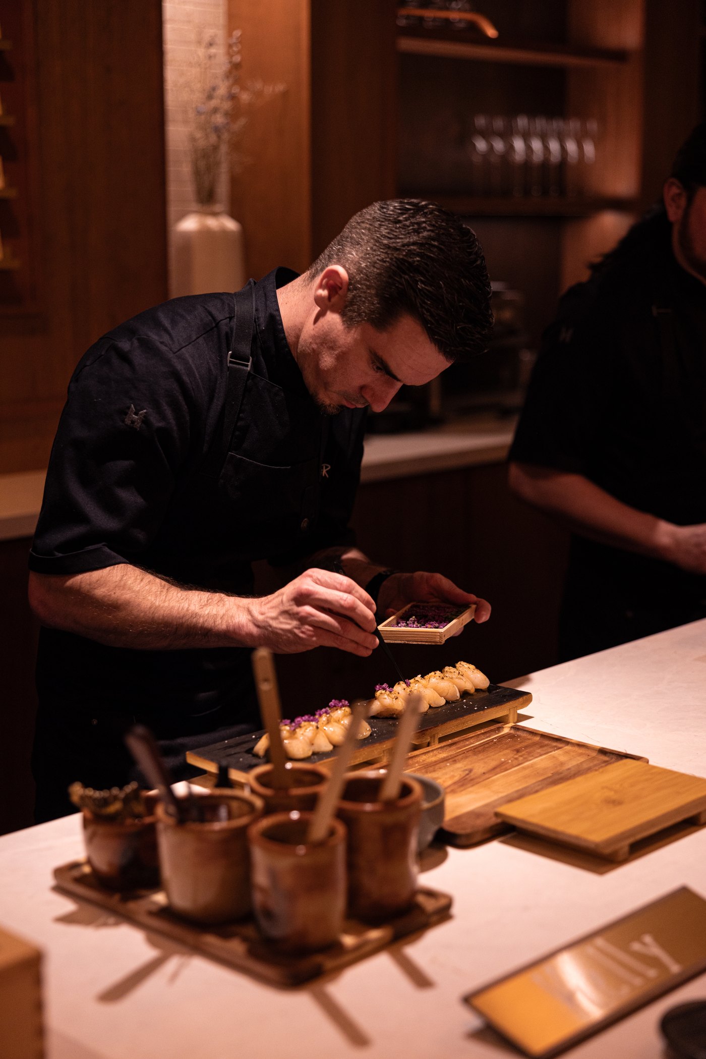 A chef plating nigiri at the Sushi | Bar counter